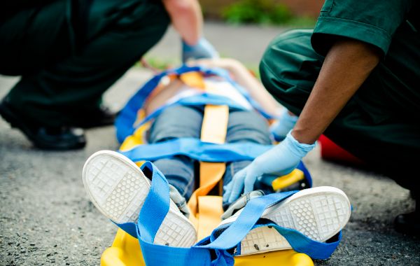 Injured man on a stretcher receiving assistance for Road Accident Fund claims through NUR Legal Services in Umhlanga.